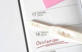 Ovulationstest und Kalender mit Eintragung des Eisprungs